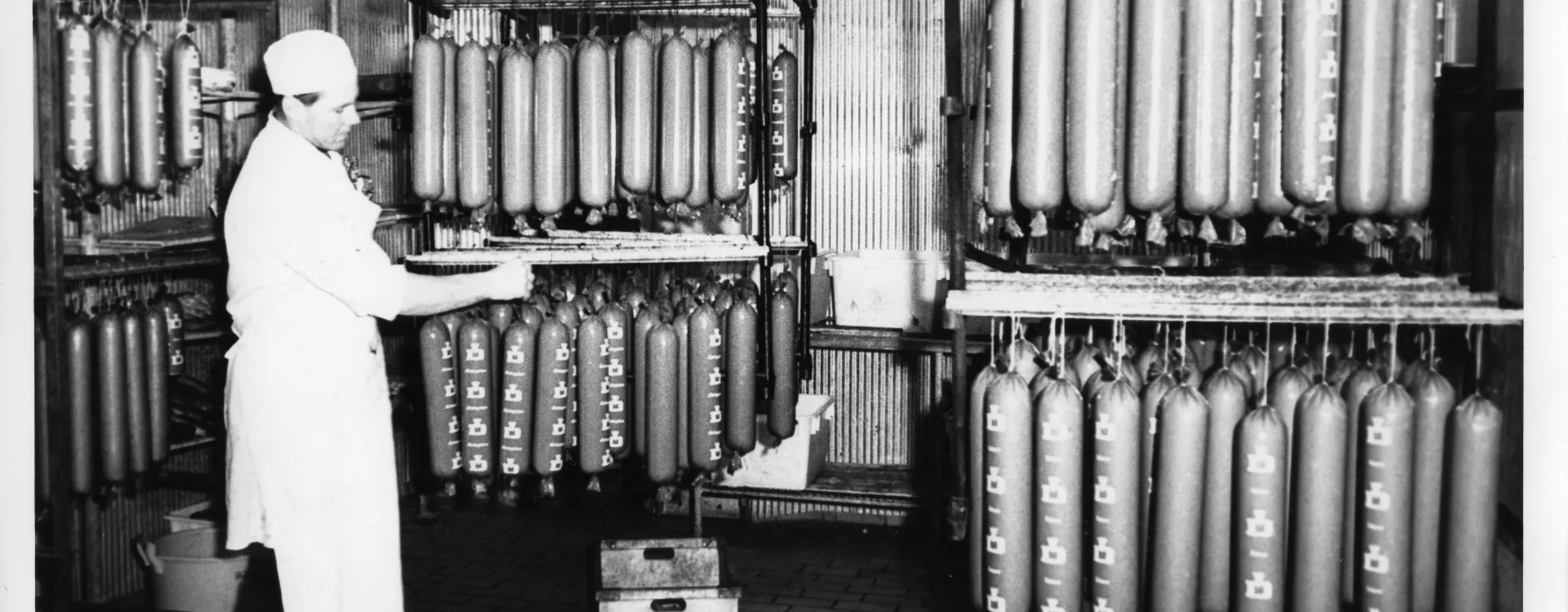 Äldre interiörbild från Dahlmans korvfabrik med hängande lördagskorvar.