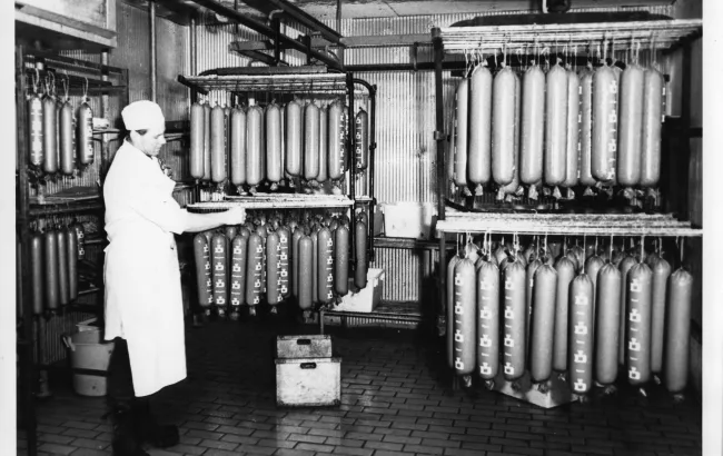 Äldre interiörbild från Dahlmans korvfabrik med hängande lördagskorvar.